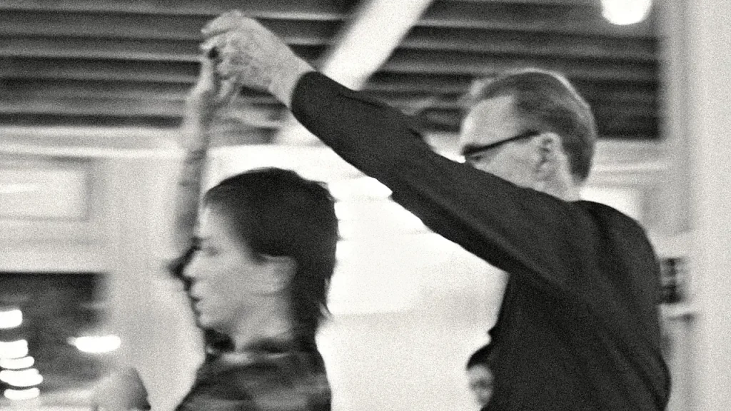 Black and white photo of a couple mid-turn on the Beach Ballroom floor, his arm raised to lead her under