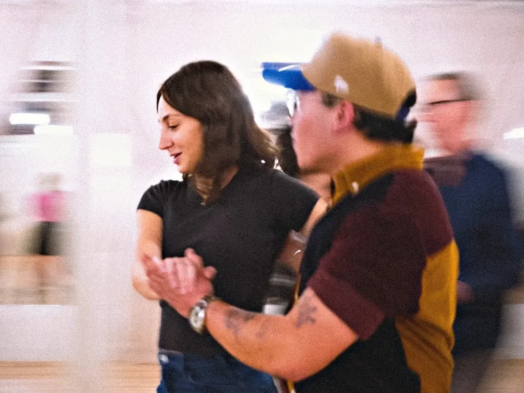 Partners dancing at a Beach Ballroom social night, the room a blur of movement behind them