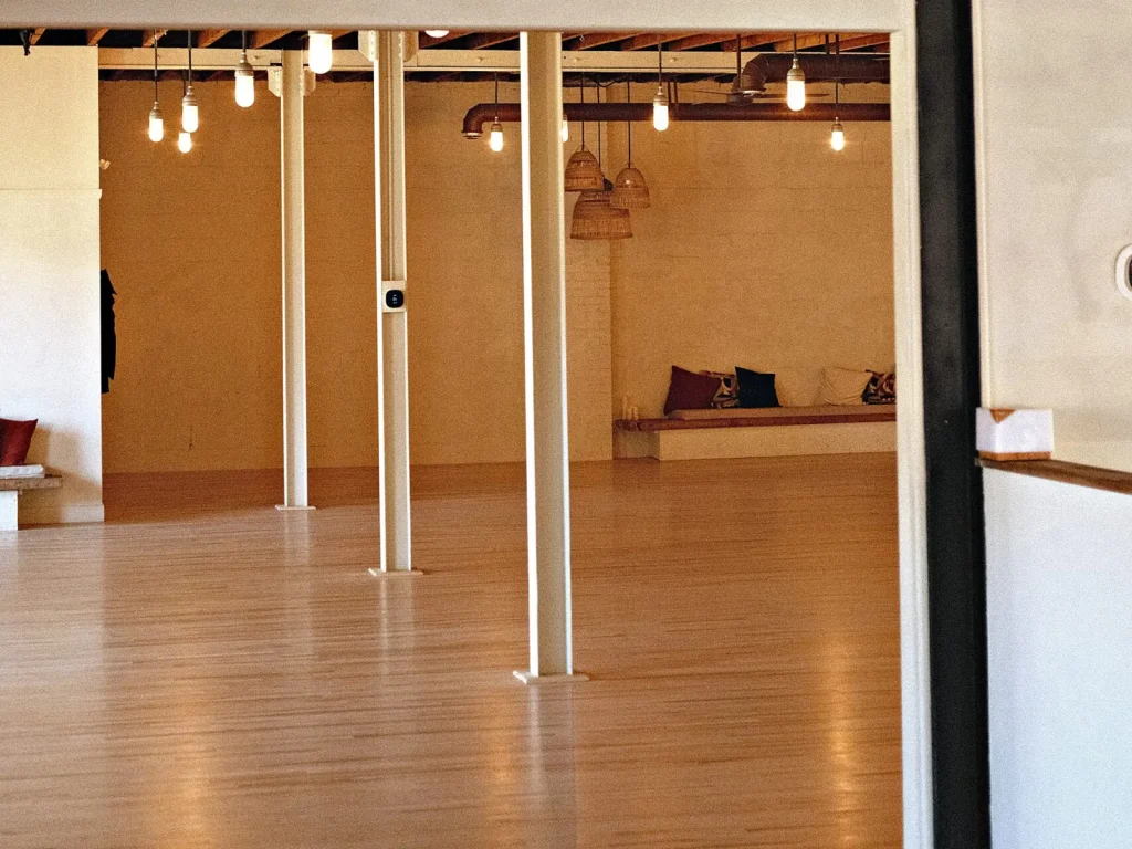 The empty Beach Ballroom studio in daylight, white columns and a wooden floor