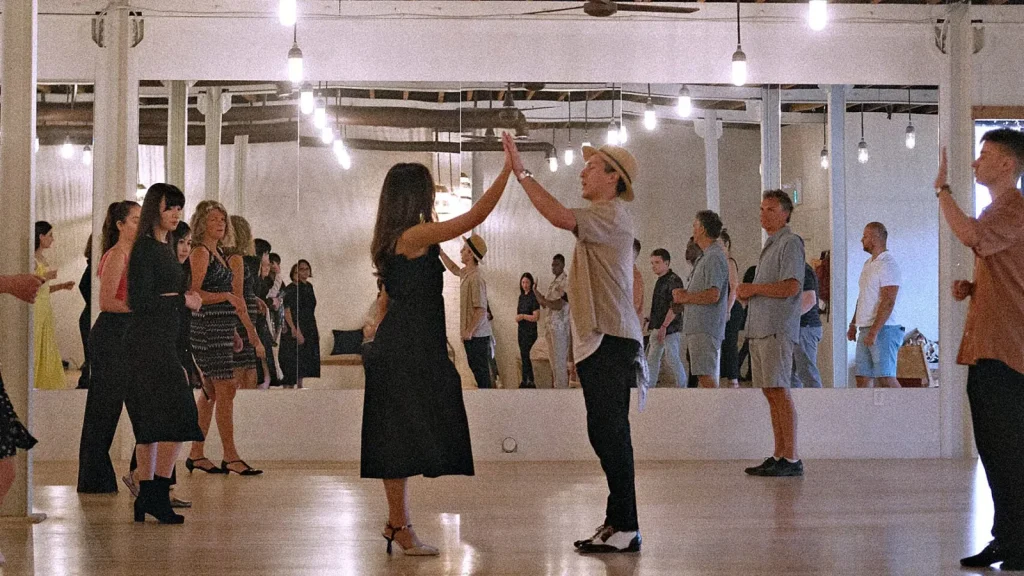 A group class practising in rows across the Beach Ballroom floor, mirrors along the back wall