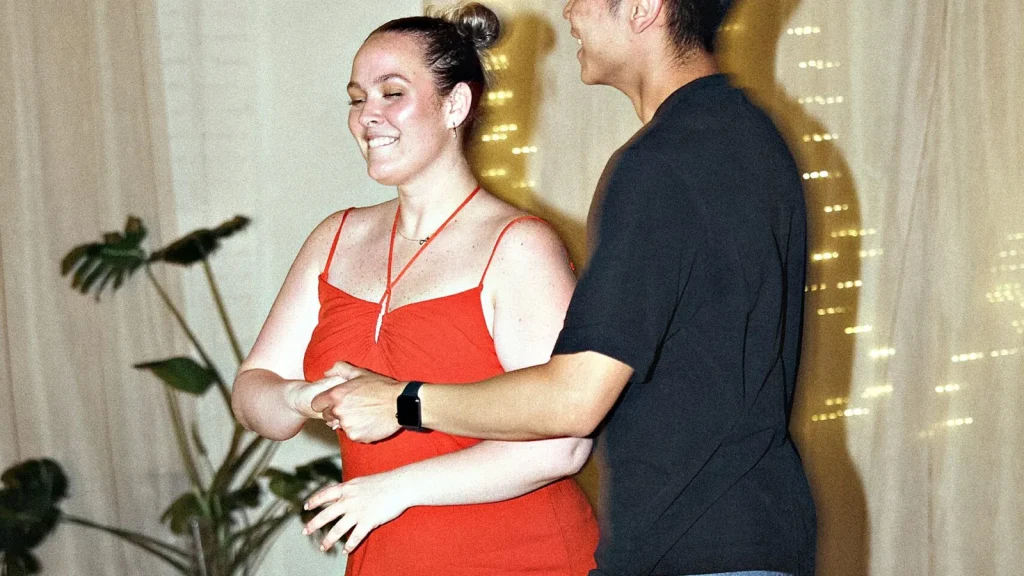 A smiling couple dancing in front of the fairy-light curtain at a Beach Ballroom evening social