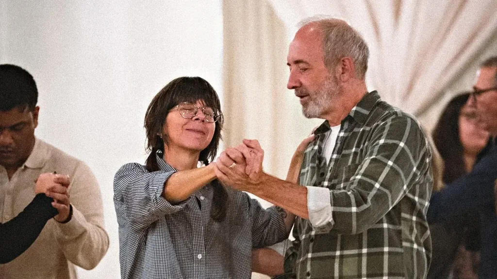 An older couple dancing in hold among other dancers at a Beach Ballroom social