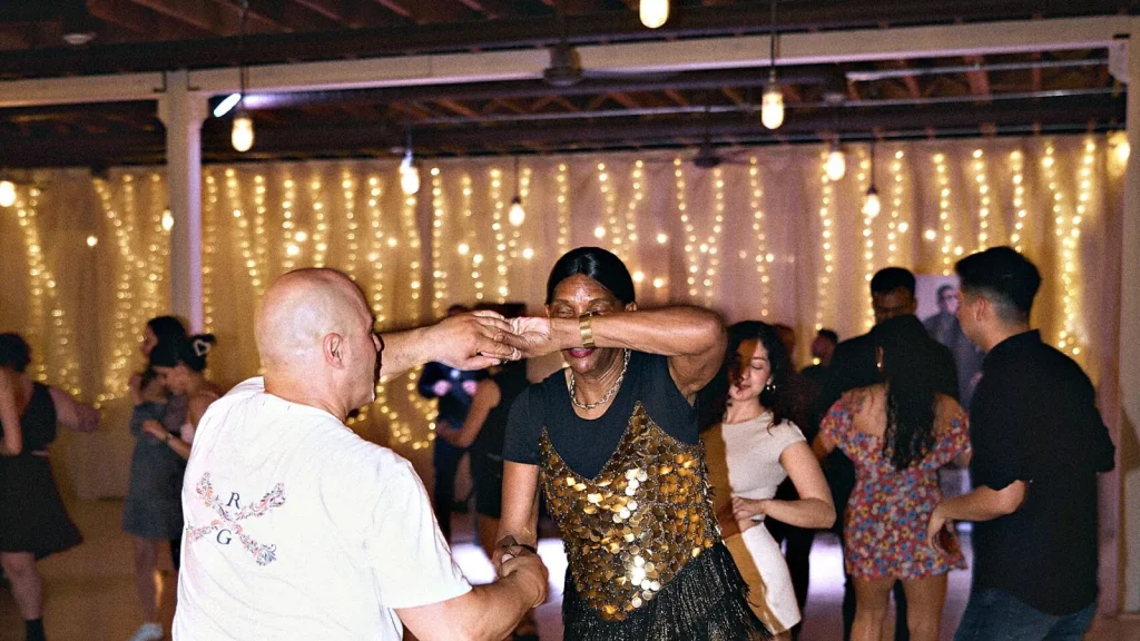 A couple dancing salsa in the middle of a busy social night at Beach Ballroom